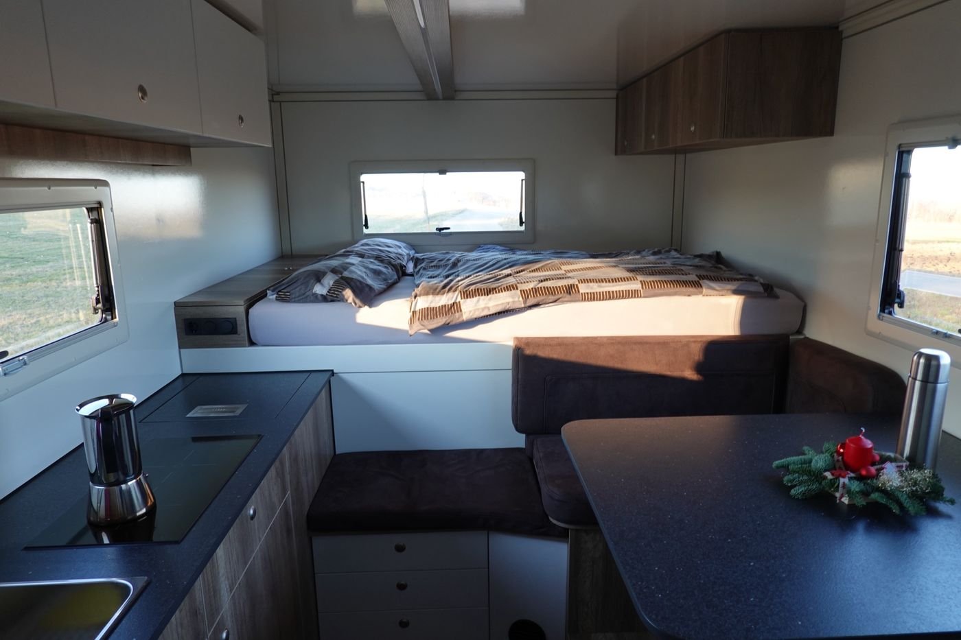 Wohnbereich mit Doppelbett, Sitzecke und Küche